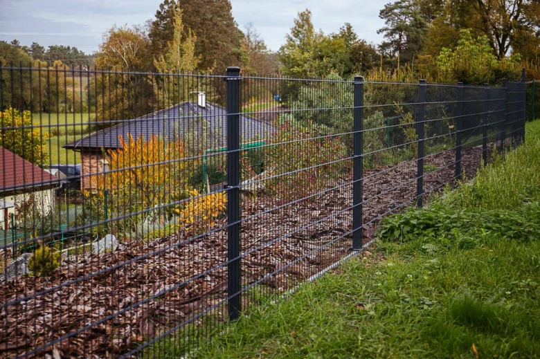 Moderní plot na hranici pozemku s přírodním okolím