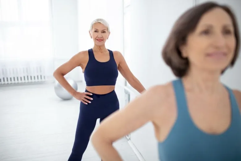 Dvě seniorky v sportovním oblečení ve fitness centru.