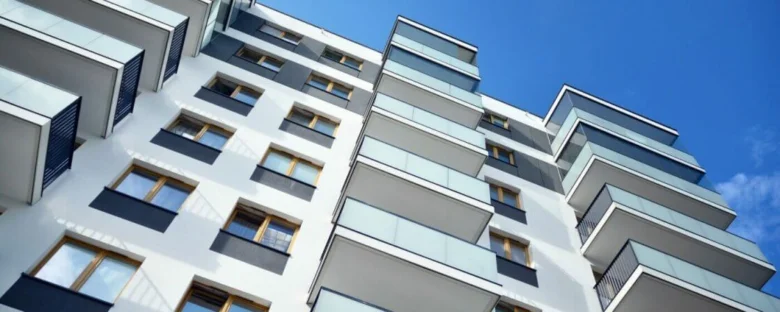 Modernní bytový dům s balkony na modré obloze
