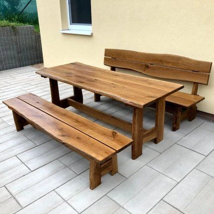 Dřevěný zahradní nábytek sestávající z jídelního stolu a laviček.
