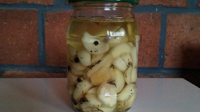 Česnek v oleji s bylinkami ve sklenici