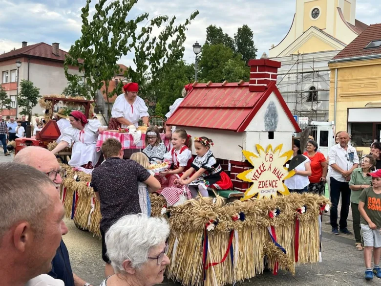 Tradiční české slavnostní průvod s lidmi v národních kostýmech na dožínkách.