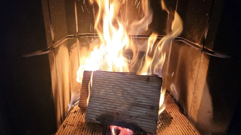Hořící dřevo v kamně, plameny a iskry