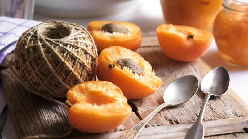 Čerstvá meruňka a domácí marmeláda na dřevěném prknu.