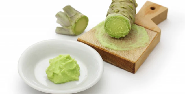 Čerstvý kořen a nastrouhaná pastva z rostliny wasabi.