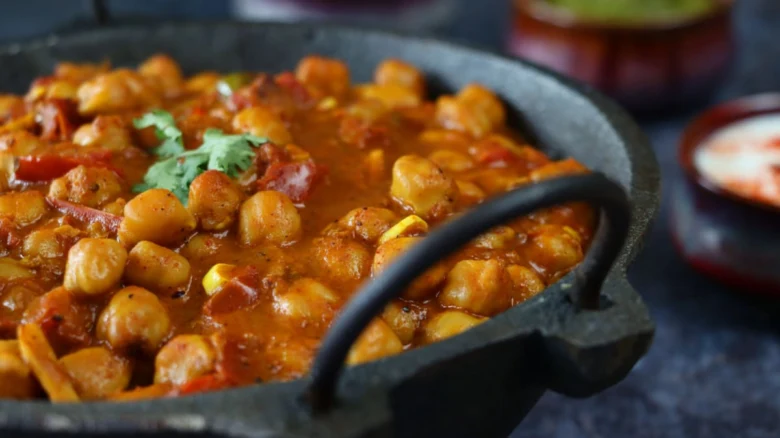 Chana masala v železném hrnci s koriandrem.