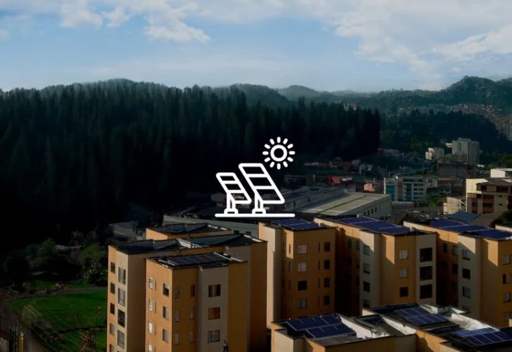 Fotovoltaické panely na střechách bytových domů v krajině.