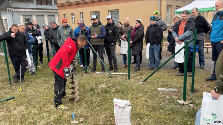 Muž kopá díru pod plotový sloup ručním nástrojem.
