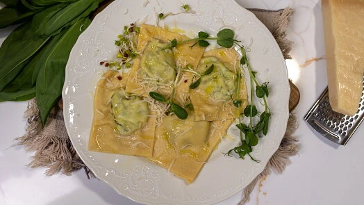 Připravené ravioly se špenátem a sýrem na bílém talíři.