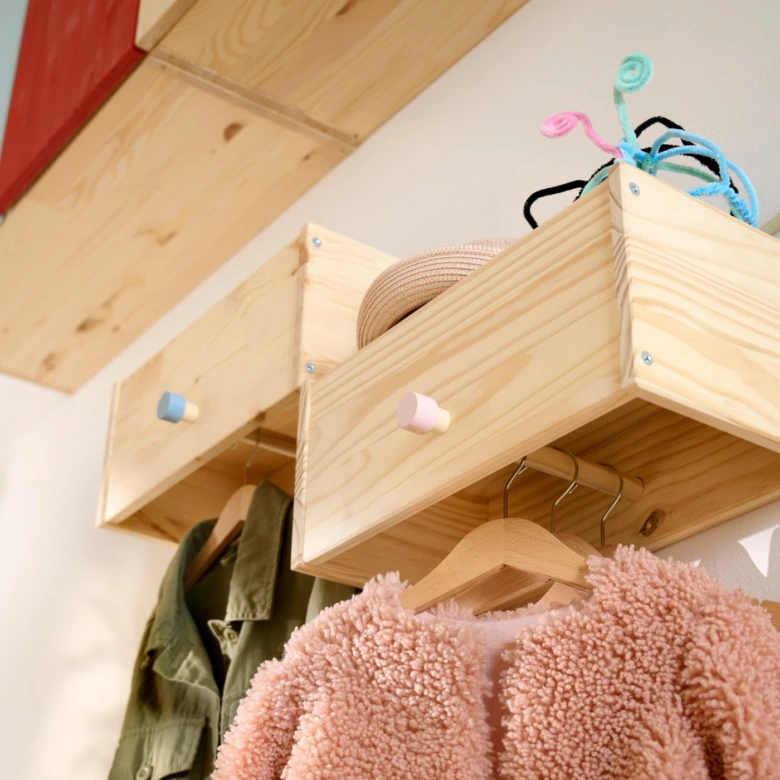 Dřevěné úložné boxy na stěně s visícími oblečení pro domácnost