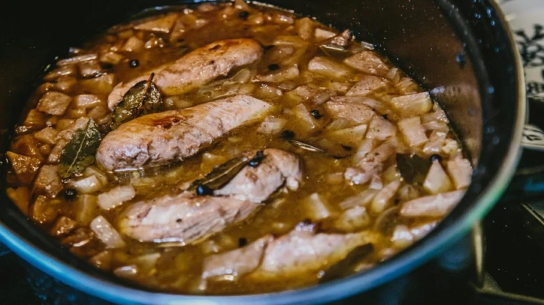 Hot pan with meat cooking in celery sauce.