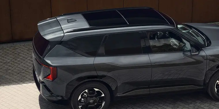 Šedý automobil typu SUV parkovaný na dlažbě.