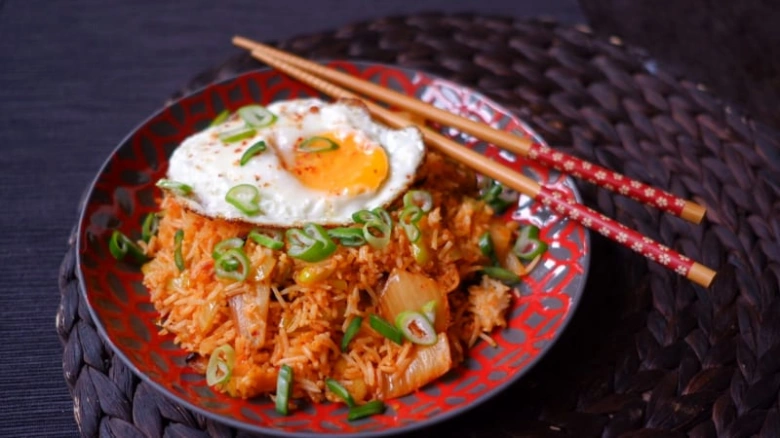 Zapečená rýže s vejcem a kimchi na talíři.