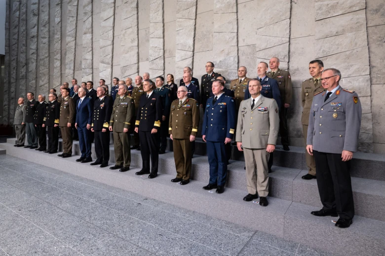 Skupina vojenských velitelů v uniformách stojí na schodech.