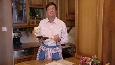 Man in kitchen with book