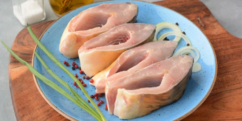 Surové rybí placky s bylinkami na modrém talíři.