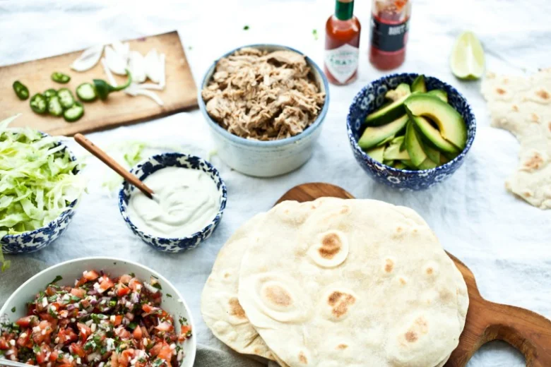 Suroviny pro domácí tortilly: maso, avokádo, salsa, zelenina.