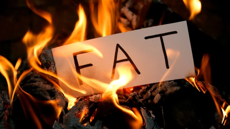 Bílý papír s nápisem FAT hoří v ohni.