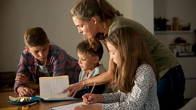 Matka pomáhá dětem s domácími úkoly ve studiu.