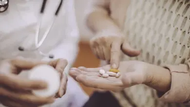Lékař ukazuje pacientovi tablety při konzultaci o medikamentózní léčbě.