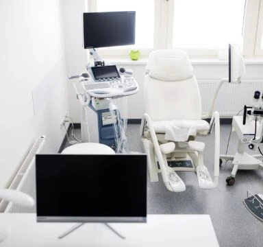 Modern lékařský vyšetřovací pokoj s židličkou pro pacienta.