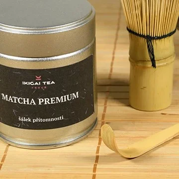 Kanec s matchou, bambusový šlehač a lžička na podložce.