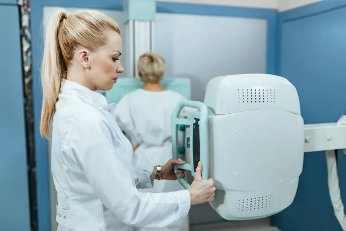 Zdravotní sestra upravuje rentgenový přístroj v nemocnici.