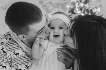 Family kissing baby at christmas